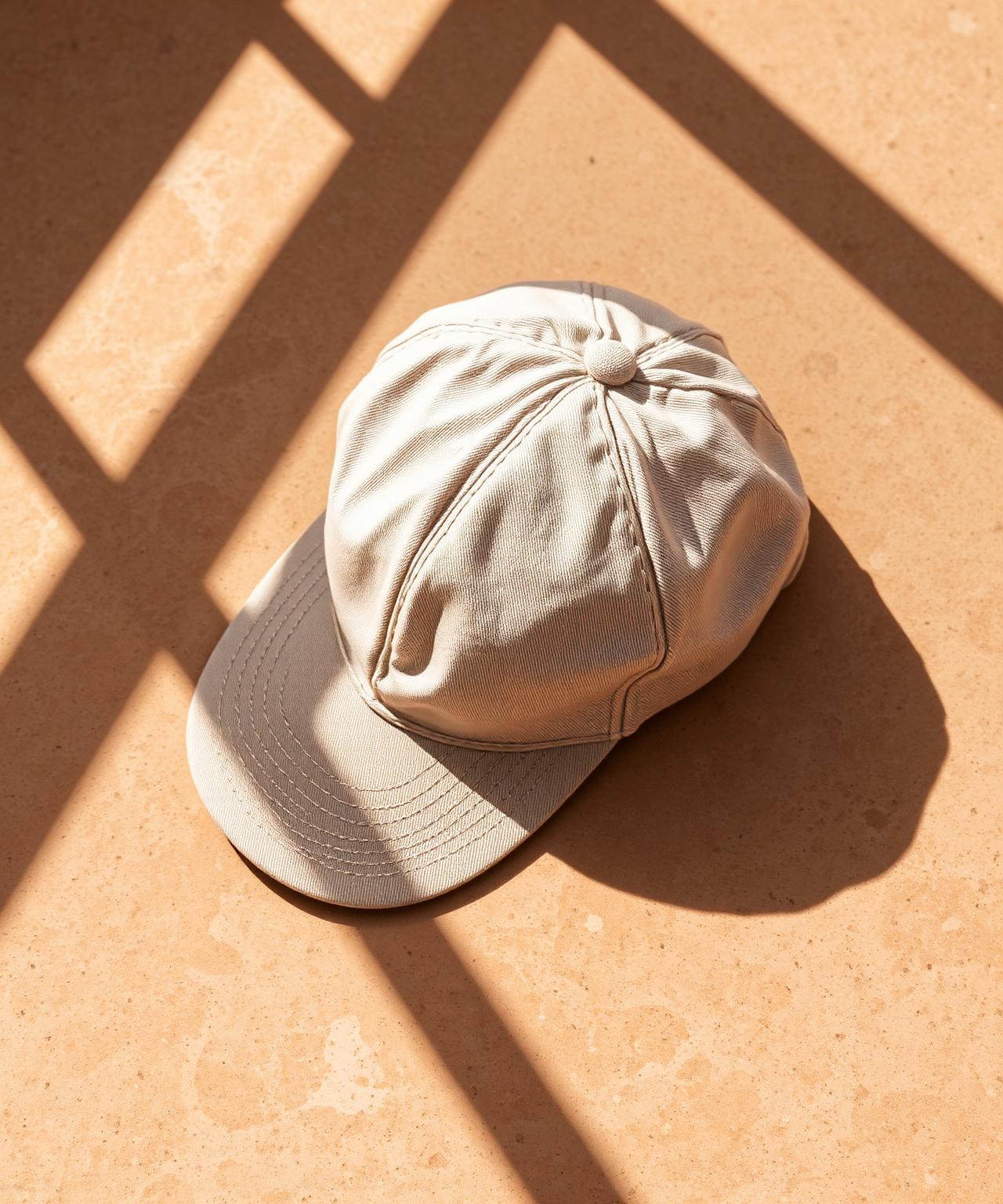 Ragazzoz linen cap resting on travertine stone in Mediterranean light